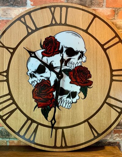 Horloge bois impression époxy de cranes squelettiques entourées de rose rouge